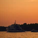 Yachts on water at sunset