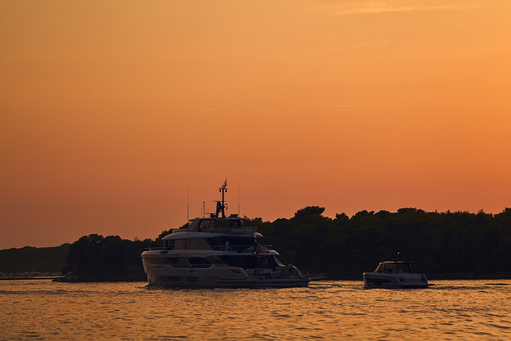 Yachts on water at sunset