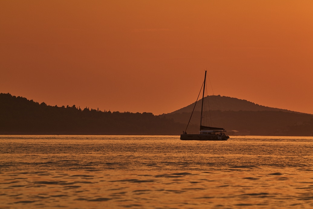 Sailboat on calm water at sunset